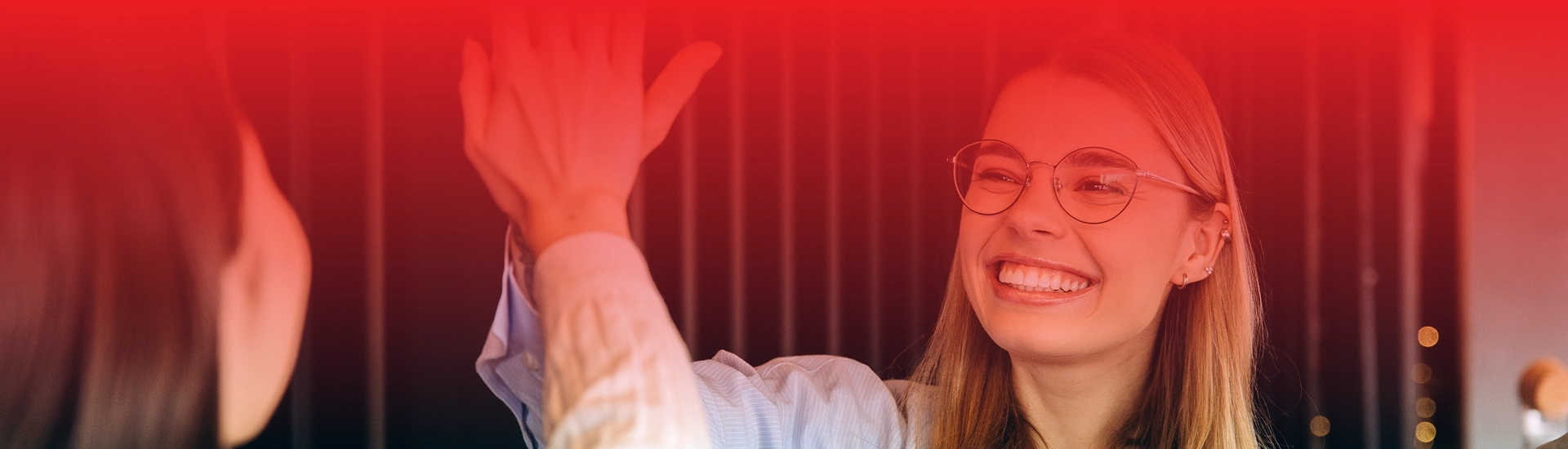 Dwie uśmiechnięte osoby przybijają sobie piątkę.